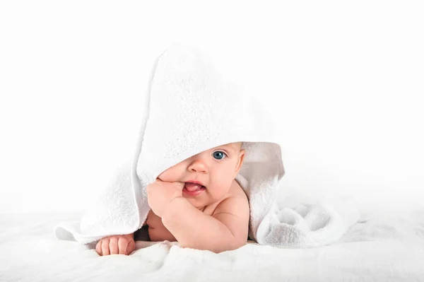 Aranyos baba 5 hónapos fehér törölközőben szopja a hüvelykujját közelről... — Stock Fotó
