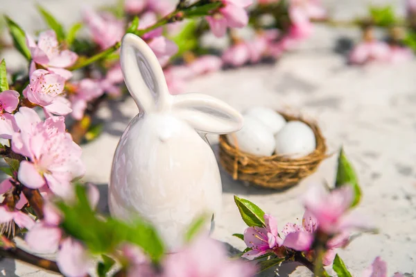 Весенний цветок, Пасхальная концепция, миниатюрный кролик, цветущее дерево крупным планом и копировальное пространство. Розовая натуральная текстура натурального цветущего дерева. Пасхальное яйцо и ветви цветения на столе.. — стоковое фото