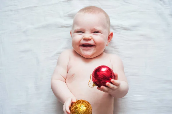 Roztomilé dítě 7 měsíců staré a vánoční koule. Můj první vánoční koncept.. — Stock fotografie