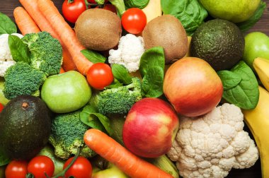 Sebzeler ve meyveler yakın plan. Karnabahar, havuç, kabak, domates, brokoli, avokado, muz, armut, elma. Seçici odak.