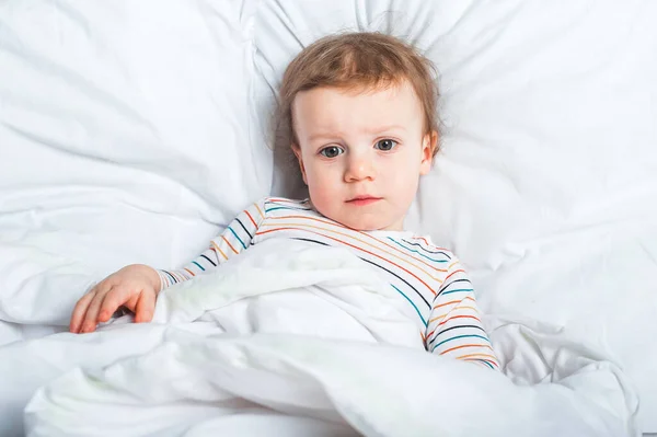Junge Kleinkind im Bett in Großaufnahme. Gesundes oder krankes Kind.. — Stockfoto