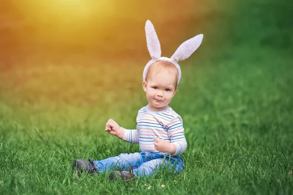 Batole vejce lovec zblízka v trávě s králičí uši... — Stock fotografie