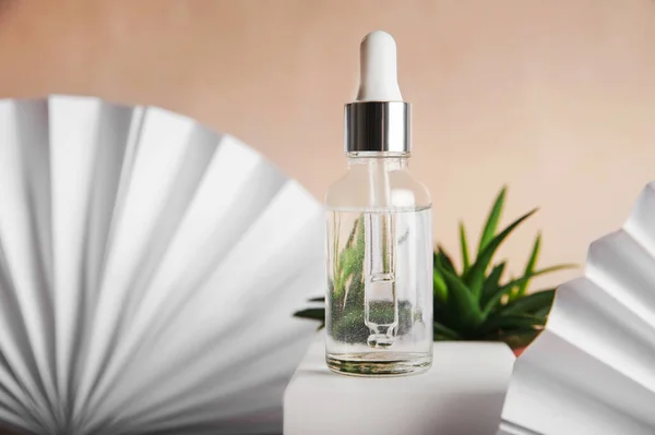Serum with pipette and aloe vera. Cosmetic natural product on white podium and paper fan... — Stock Photo, Image