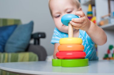 Küçük çocuk eğitici tahta ve plastik oyuncaklarla oynuyor.