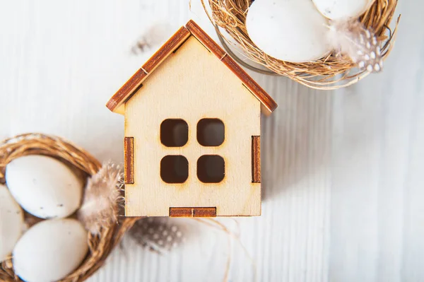 Frohe Ostern Glückwunschkarte. Miniatur-Holzhaus. Kaninchen, bunte Eier, Frühlingsblumen mit Anhänger für Text.. — Stockfoto