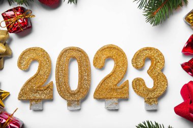 Mutlu yıllar 2023 tebrik kartı. Beyaz arka planda mum numaraları ve Noel ağacının yerleşimi, toplar, hediyeler. Boşluğu kapat ve kopyala, Seçmeli odak..