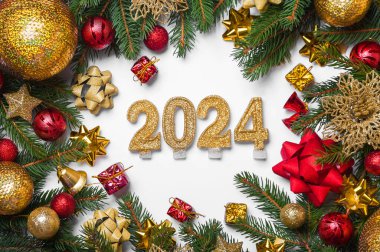 Mutlu yıllar 2024 tebrik kartı. Beyaz arka planda mum numaraları ve Noel ağacının yerleşimi, toplar, hediyeler. Boşluğu kapat ve kopyala, Seçmeli odak..