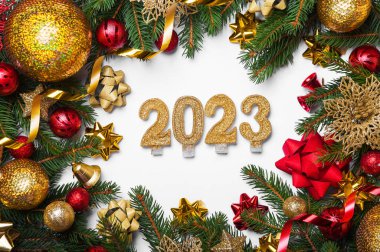 Mutlu yıllar 2023 tebrik kartı. Beyaz arka planda mum numaraları ve Noel ağacının yerleşimi, toplar, hediyeler. Boşluğu kapat ve kopyala, Seçmeli odak.
