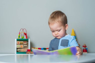 Küçük çocuğun portresi evdeki çocuk odasında kitap okuyor..