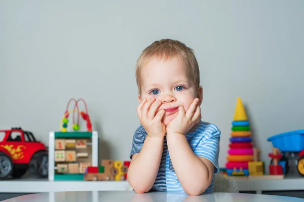 Portrait of toddler boy with facial expressions in interior of childrens room at home.. — Stockfoto