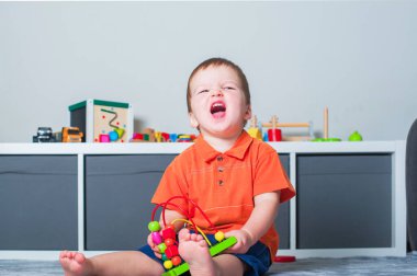 Küçük çocuk oyun odasında eğitici oyuncaklarla oynuyor..