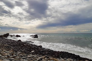 Bir çakıl taşı plajında dalgalar ve Liguria 'daki Diano Marina' da deniz manzarası, İtalya 'daki seyahat ve manzaralar.