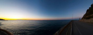 Liguria 'daki Diano Marina' da gökyüzünü turuncu ve denizle renklendiren, İtalya 'daki seyahat ve manzaraları gösteren güzel bir gün doğumunun özeti.