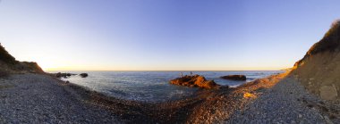 Gökyüzünü portakalla renklendiren, Liguria 'daki Diano Marina' da deniz manzarası, İtalya 'daki seyahat ve manzaralarla renklendiren güzel bir güneşin kumsalında panoramik.