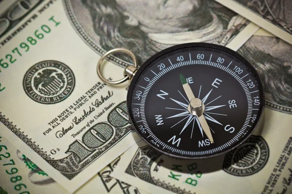 Monedas en dólares estadounidenses con brújula —  Fotos de Stock