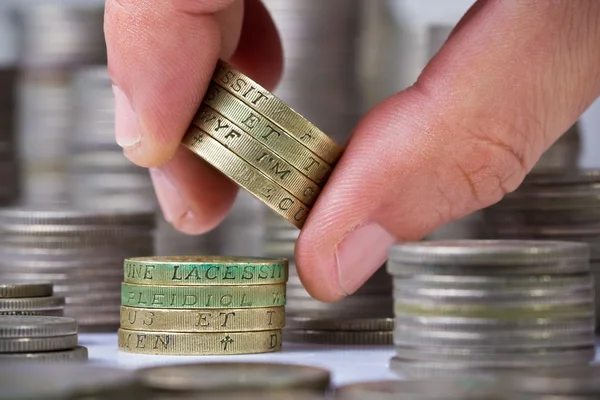 Closeup of a hand withdraws british pound coins from the stack — Stock Photo, Image