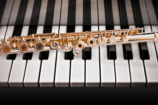 14k Rose gold flute on a piano keys — Stock Photo, Image