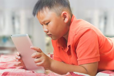 Genç Asyalı çocuk ile bir tablet bilgisayar