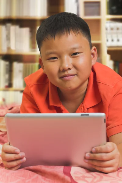 Giovane asiatico ragazzo con un tablet computer — Foto Stock