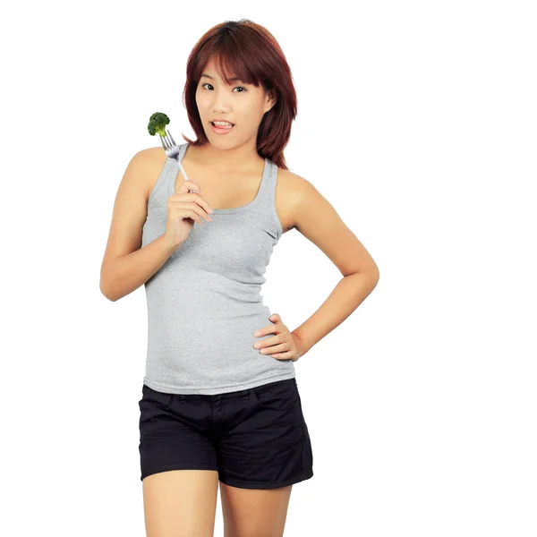 Geïsoleerde jonge Aziatische vrouw met een picec van brocolli — Stockfoto