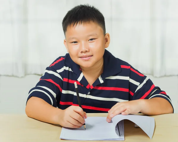 Молодий азіатський хлопчик щасливий своїм домашнім завданням — стокове фото