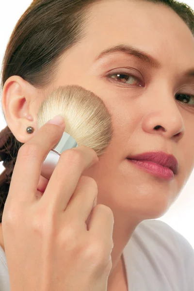 Isolated middle age asian woman with make up brush. — Stock Photo, Image