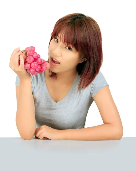 Geïsoleerde jonge Aziatische vrouw met druiven over Wit. — Stockfoto