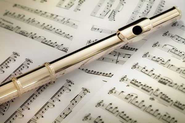 14 K rose gold of a flute headjoint on music sheets — Stock Photo, Image