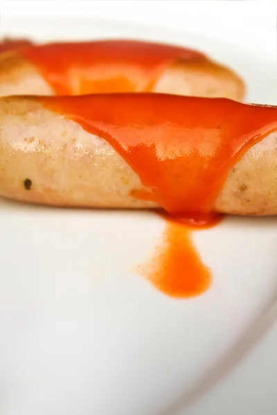 Enchidos com molho de pimenta quente em um prato branco — Fotografia de Stock