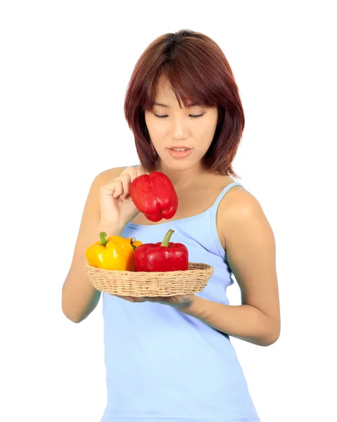 Isolated young asian woman with a red and yellow paprika — Stock Photo, Image