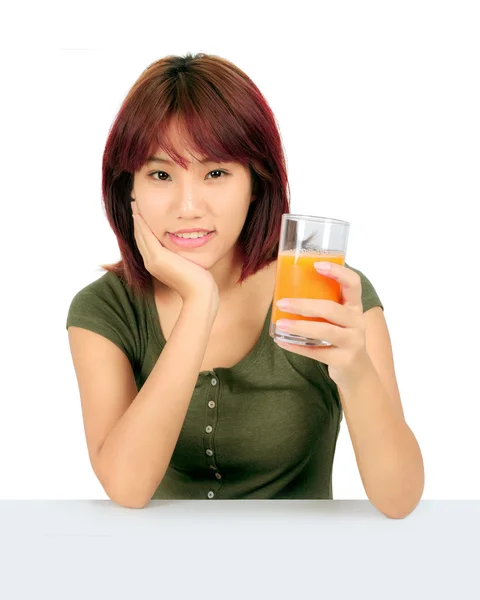 Isolated young asian woman with a glass of orange juice — Stock Photo, Image
