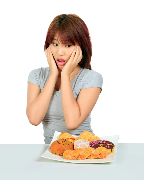 Aislado joven asiático mujer con un donuts en la mesa — Foto de Stock