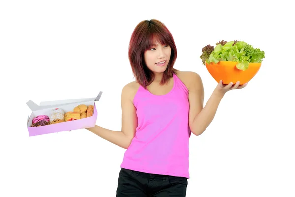 Mujer asiática joven aislada con una caja de rosquillas y un tazón de verduras —  Fotos de Stock