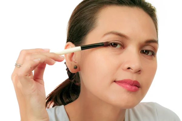 Femme d'âge moyen isolée avec une brosse de maquillage — Photo