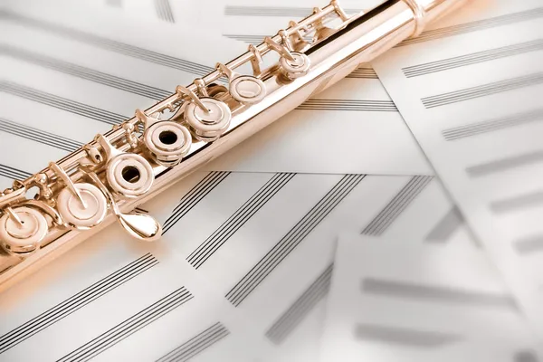 14K rose gold upper middle joint of the flute on blank music sheets — Stock Photo, Image