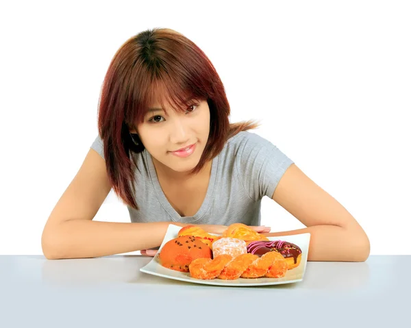 Aislado joven asiático mujer con un donuts en la mesa —  Fotos de Stock