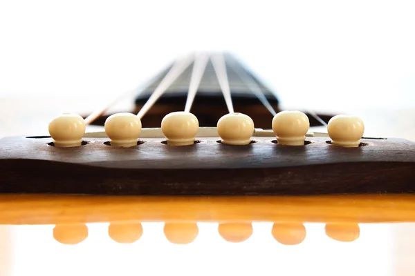 Close-up op de pinnen op de brug van een akoestische gitaar — Stockfoto