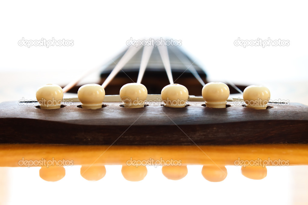 Closeup at the pins on the bridge of an Acoustic Guitar