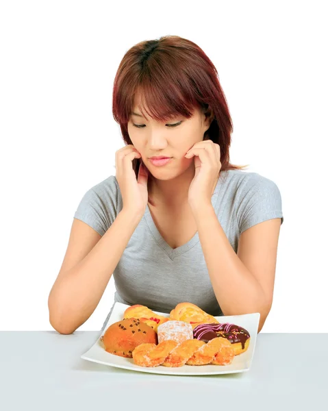 Aislado joven asiático mujer con un donuts en la mesa — Foto de Stock