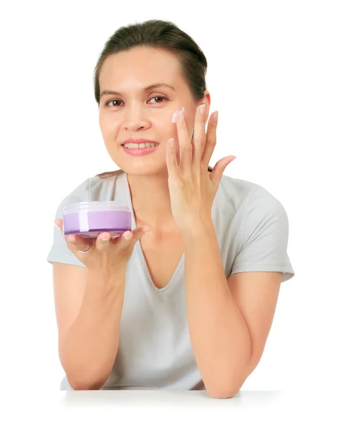 Isolated Middle Age Asian Woman apllies cream on her face. — Stock Photo, Image