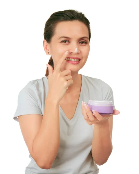 Isolé moyen âge asiatique femme apllies crème sur son visage . — Photo