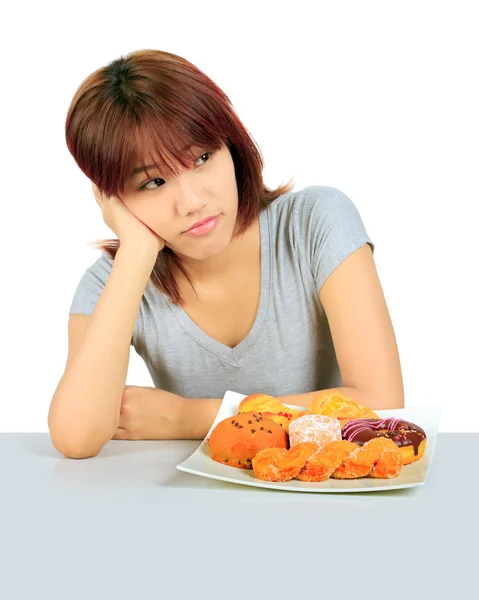 Aislado joven asiático mujer con un donuts en la mesa — Foto de Stock