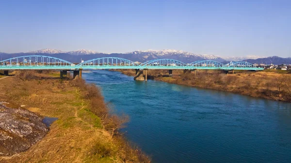 Зеленый мост, пересекающий реку — стоковое фото
