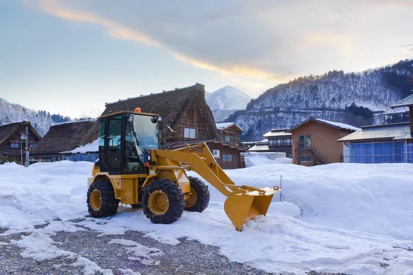 Желтый трактор зимой — стоковое фото