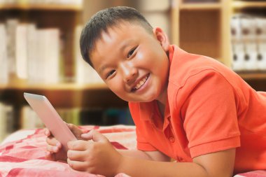 Genç Asyalı çocuk ile bir tablet bilgisayar