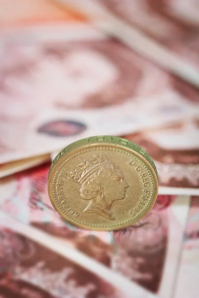 Närbild av ett brittiskt pund mynt på brittiska pund sedlar — Stockfoto