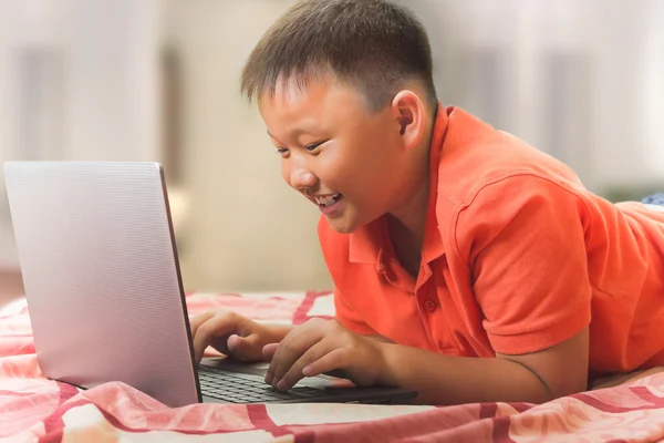 Asian boy working on a laptop computer — Stock Photo, Image