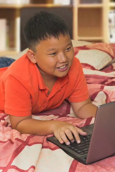 Азиатский мальчик, работающий на ноутбуке — стоковое фото