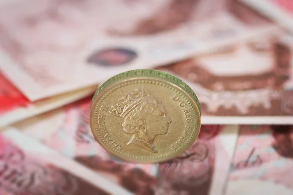 British pound coin placed on British pound banknotes