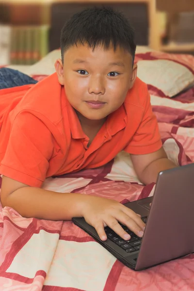 Asian boy working on a laptop computer — Stock Photo, Image